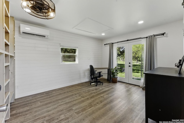 office featuring a wall mounted AC, french doors, baseboards, and wood finished floors