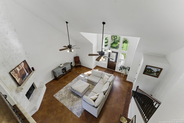 tiled living area featuring ceiling fan and a fireplace with raised hearth