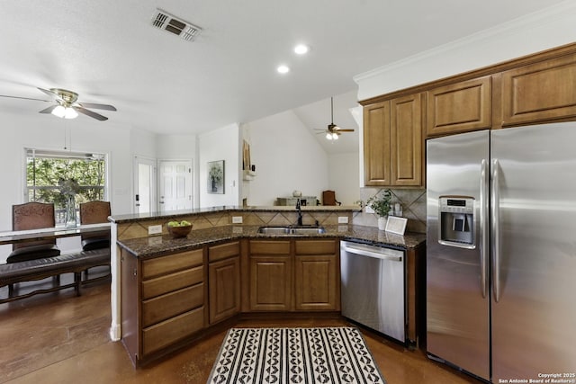 kitchen featuring visible vents, a sink, ceiling fan, a peninsula, and stainless steel appliances