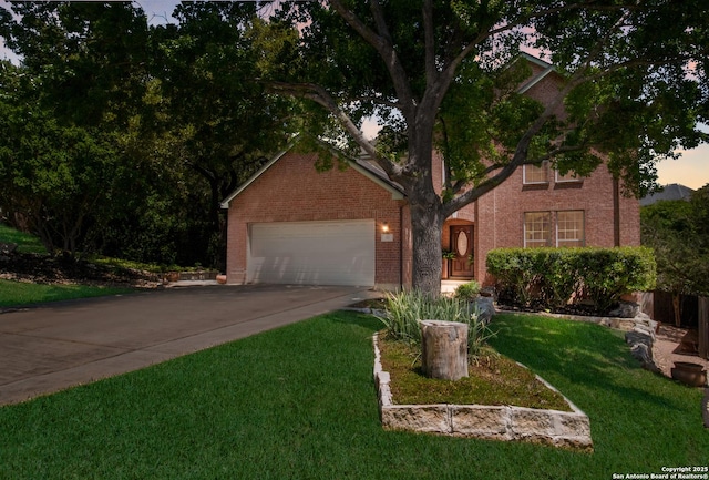 view of front of home with concrete driveway, a front yard, brick siding, and an attached garage