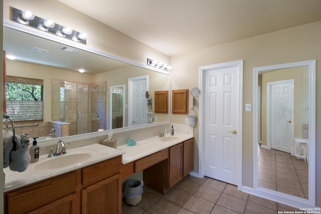 bathroom with visible vents, a sink, double vanity, tile patterned flooring, and a stall shower
