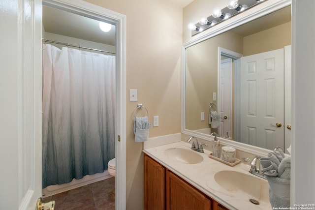 bathroom with tile patterned flooring, double vanity, a sink, and toilet