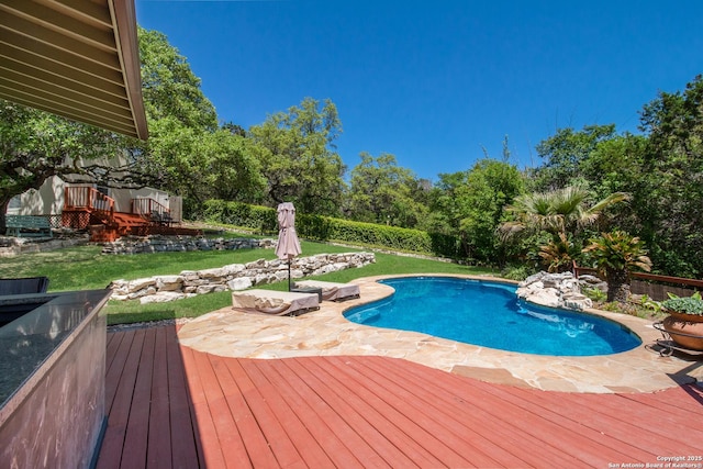 view of swimming pool featuring a patio, a yard, a wooden deck, and a fenced in pool