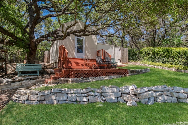 back of property with a wooden deck and a lawn