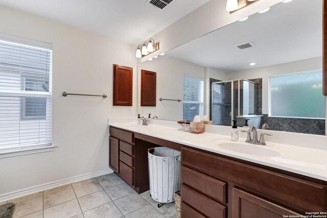 26019 Florencia Villa, Boerne, TX 78015 - full bathroom featuring double vanity, a stall shower, tile patterned floors, visible vents, and a sink