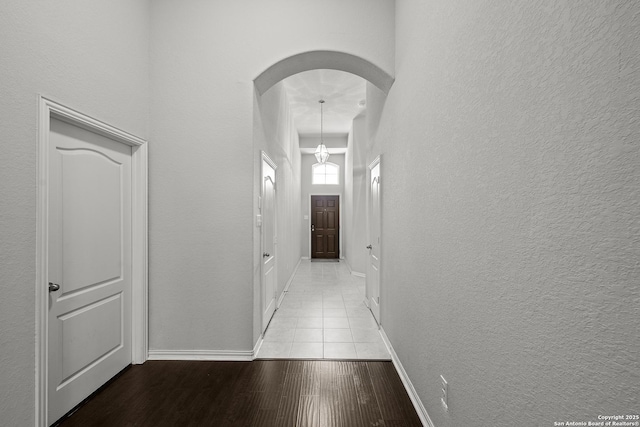 7635 Mission Smt, Boerne, TX 78015 - hallway with arched walkways, wood finished floors, a textured wall, and baseboards