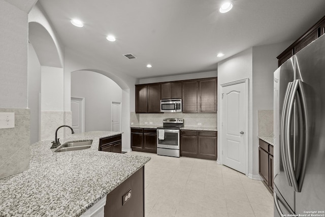 7635 Mission Smt, Boerne, TX 78015 - kitchen featuring light stone countertops, visible vents, stainless steel appliances, arched walkways, and a sink