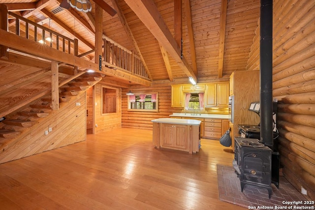 463 Woodland, Fredericksburg, TX 78624 - kitchen with wood ceiling, a wood stove, light countertops, beamed ceiling, and rustic walls