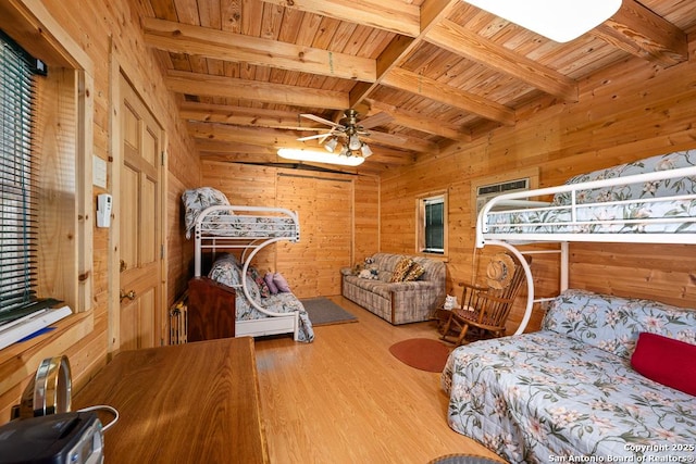 463 Woodland, Fredericksburg, TX 78624 - bedroom featuring ceiling fan, wood walls, wood finished floors, wooden ceiling, and beamed ceiling