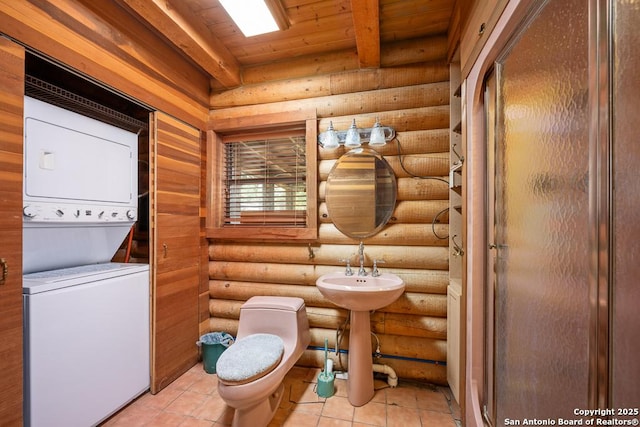 463 Woodland, Fredericksburg, TX 78624 - bathroom featuring log walls, stacked washing maching and dryer, toilet, and wooden ceiling