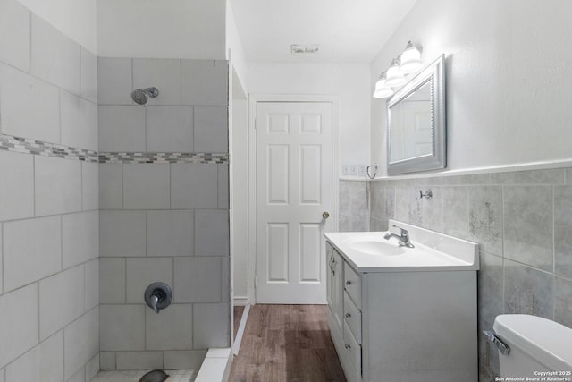123 Haby Dr, San Antonio, TX 78212 - full bathroom with vanity, toilet, tiled shower, tile walls, and wood finished floors