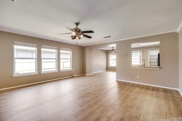 6611 Millrock, Live Oak, TX 78233 - unfurnished room featuring light wood-style flooring, a textured ceiling, ornamental molding, a ceiling fan, and visible vents