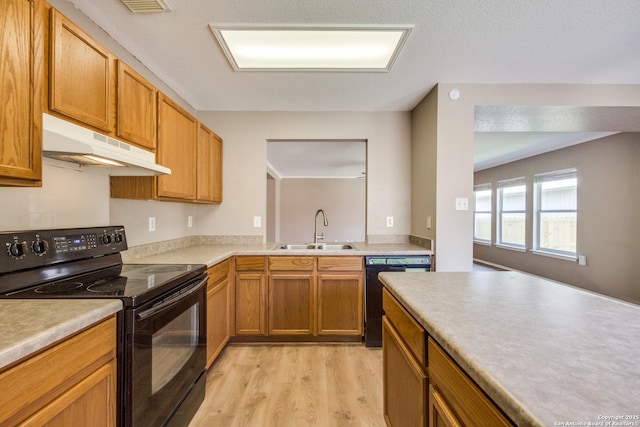6611 Millrock, Live Oak, TX 78233 - kitchen featuring light countertops, black appliances, under cabinet range hood, light wood finished floors, and a sink