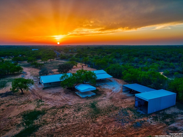 601 Wildflower Dr, Lytle, TX 78052 - aerial view at dusk featuring a forest view