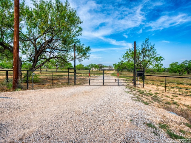 601 Wildflower Dr, Lytle, TX 78052 - view of street with a gated entry, a gate, driveway, and a rural view