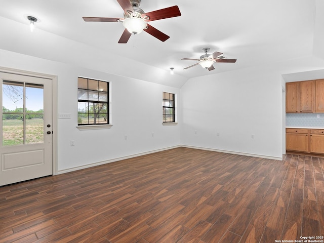601 Wildflower Dr, Lytle, TX 78052 - unfurnished living room featuring dark wood finished floors, baseboards, and a ceiling fan