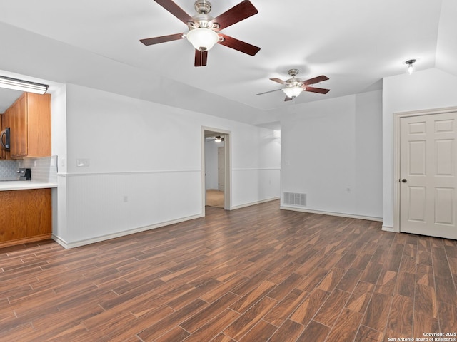 601 Wildflower Dr, Lytle, TX 78052 - unfurnished living room featuring dark wood finished floors, visible vents, baseboards, and ceiling fan