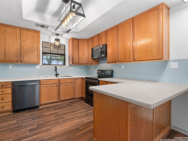 601 Wildflower Dr, Lytle, TX 78052 - kitchen featuring dark wood finished floors, a peninsula, light countertops, a sink, and stainless steel appliances