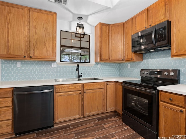 601 Wildflower Dr, Lytle, TX 78052 - kitchen featuring dark wood-style flooring, light countertops, electric range, dishwashing machine, and a sink