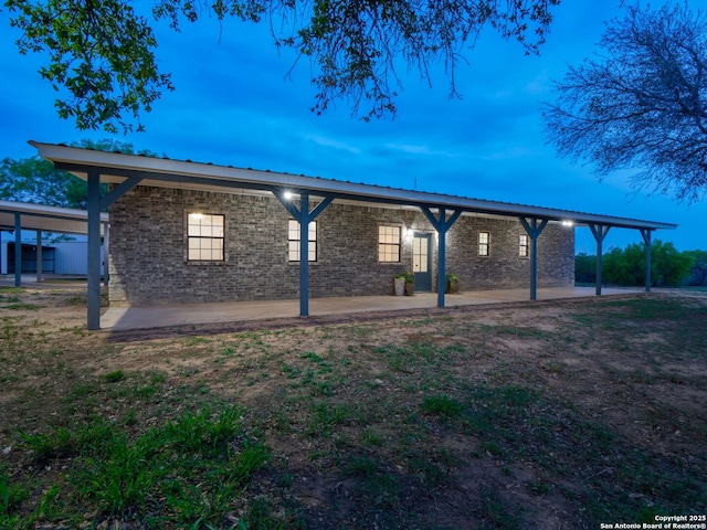 601 Wildflower Dr, Lytle, TX 78052 - exterior space with brick siding, a patio, and metal roof