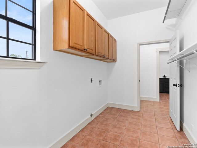 601 Wildflower Dr, Lytle, TX 78052 - washroom with hookup for an electric dryer, light tile patterned floors, baseboards, and cabinet space