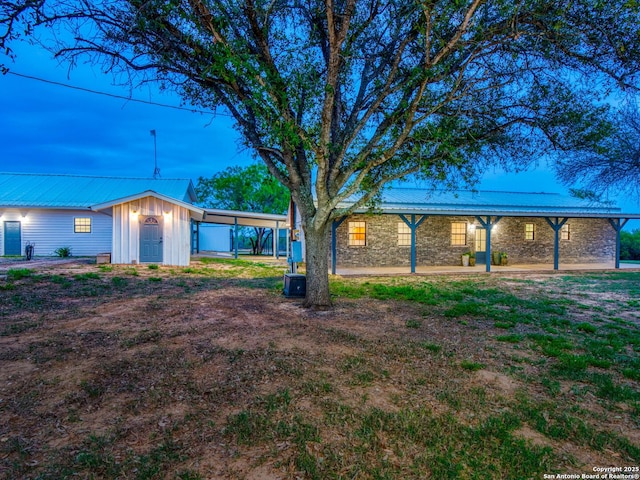 601 Wildflower Dr, Lytle, TX 78052 - ranch-style home with a carport, metal roof, board and batten siding, and stone siding