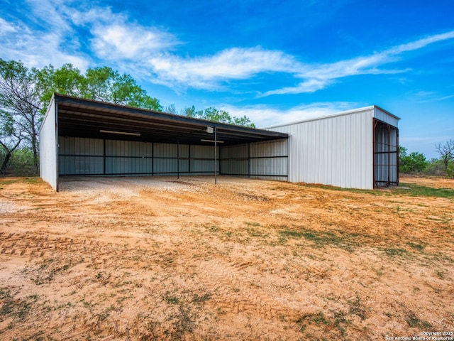 601 Wildflower Dr, Lytle, TX 78052 - view of pole building featuring a detached carport and dirt driveway