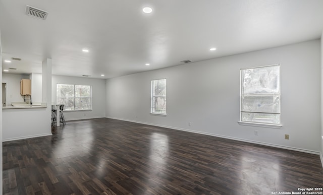 unfurnished living room featuring recessed lighting, dark wood finished floors, and baseboards