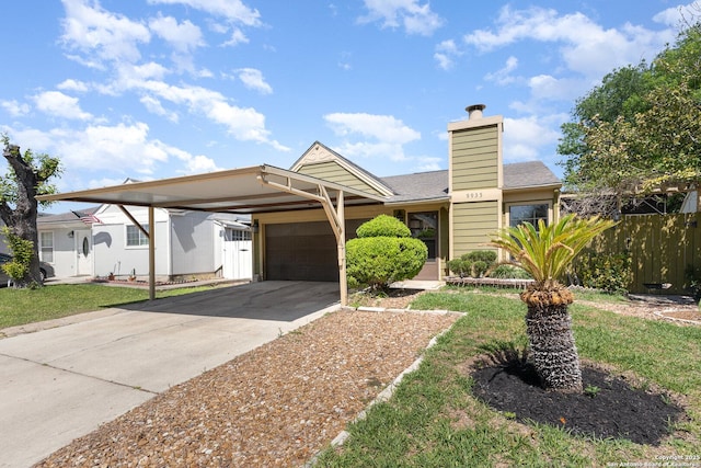 view of front facade with a garage, fence, a chimney, concrete driveway, and an attached carport