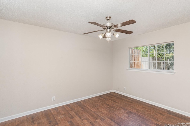 spare room featuring dark wood-style flooring, baseboards, ceiling fan, and a textured ceiling