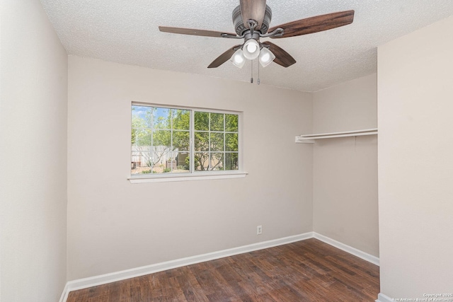 unfurnished room with dark wood-type flooring, a textured ceiling, baseboards, and ceiling fan