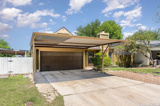 view of front of house with an attached garage, a chimney, driveway, and fence
