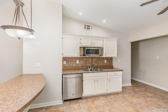 kitchen featuring ceiling fan, white cabinets, a sink, stainless steel appliances, and decorative backsplash