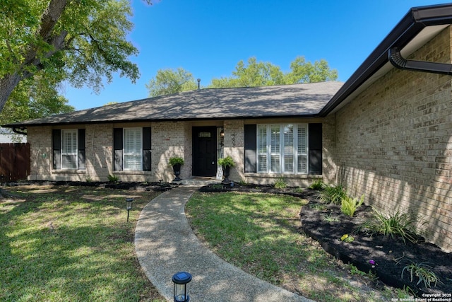 single story home with a front lawn and brick siding