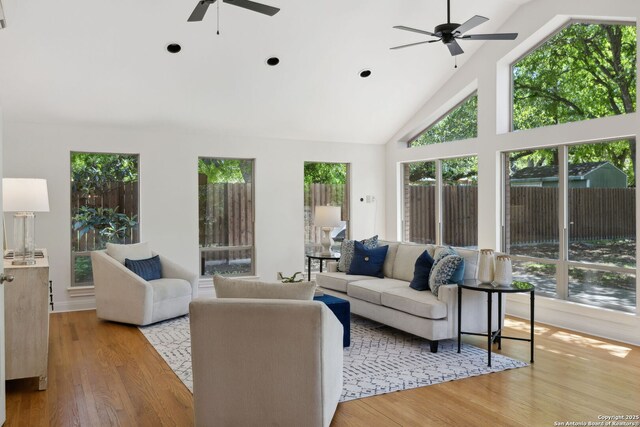 living area featuring light wood finished floors, high vaulted ceiling, a ceiling fan, and recessed lighting