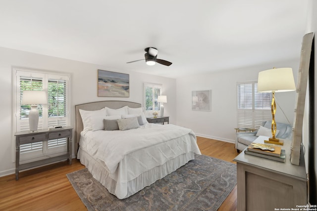 bedroom with light wood-style floors, multiple windows, and baseboards