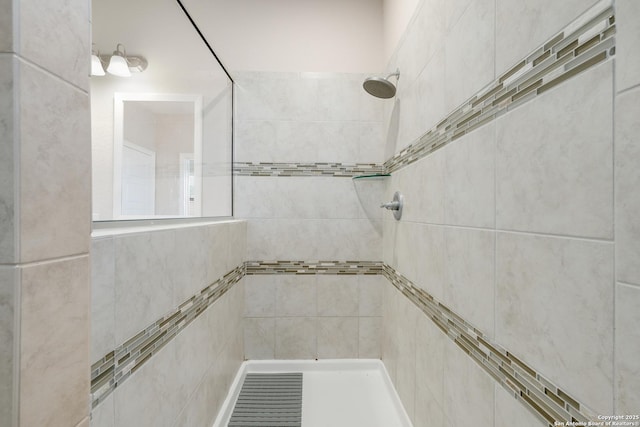 interior details featuring a tile shower