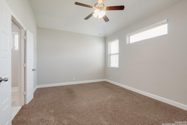 empty room featuring light carpet, baseboards, and a ceiling fan