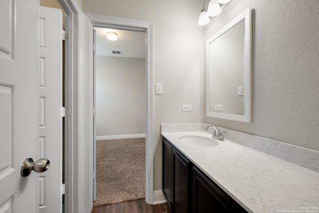 bathroom featuring visible vents, vanity, and wood finished floors
