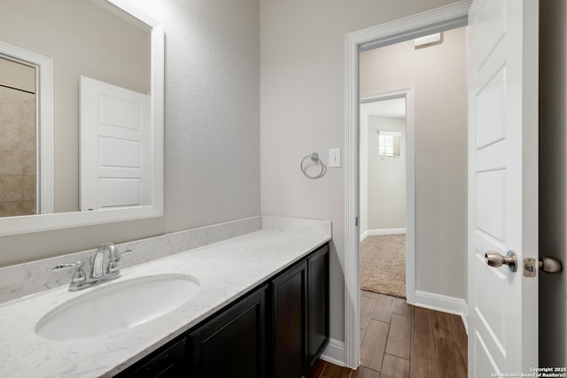 bathroom with vanity, baseboards, and wood finished floors