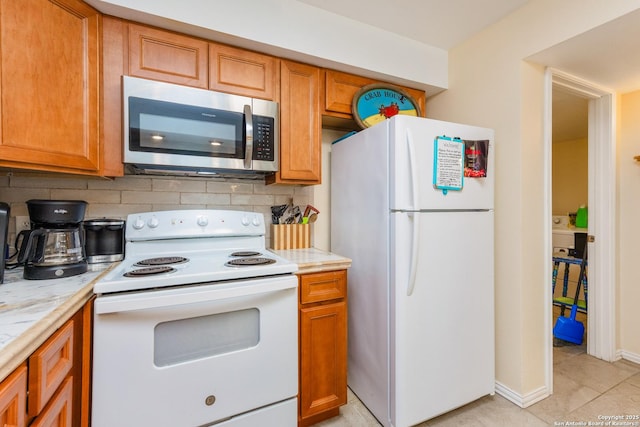 71 W Nassau Unit 302, Rockport, TX 78382 - kitchen featuring white appliances, light countertops, brown cabinetry, and decorative backsplash