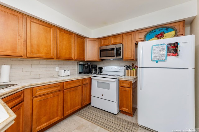 71 W Nassau Unit 302, Rockport, TX 78382 - kitchen with brown cabinetry, tasteful backsplash, and white appliances