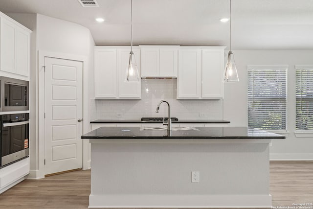 17114 Autry Fls, San Antonio, TX 78247 - kitchen featuring appliances with stainless steel finishes, backsplash, light wood-style floors, white cabinetry, and recessed lighting