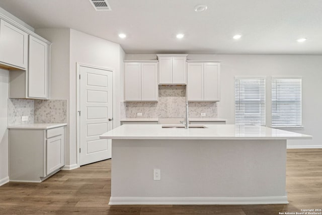 11534 Cottage Pt, San Antonio, TX 78254 - kitchen featuring a kitchen island with sink, tasteful backsplash, light wood-style flooring, light countertops, and recessed lighting