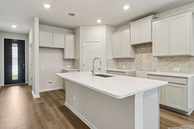 11534 Cottage Pt, San Antonio, TX 78254 - kitchen featuring an island with sink, tasteful backsplash, dark wood finished floors, recessed lighting, and white cabinets