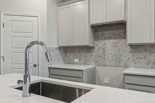 11534 Cottage Pt, San Antonio, TX 78254 - kitchen featuring light stone countertops, gray cabinets, and decorative backsplash