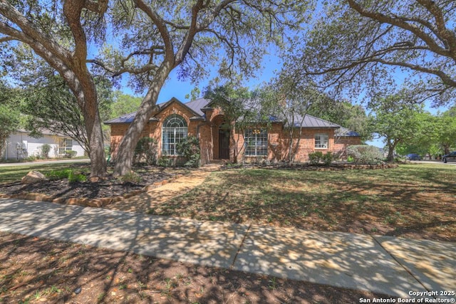 1780 Oak Frst, New Braunfels, TX 78132 - ranch-style home with a standing seam roof, a front yard, and metal roof