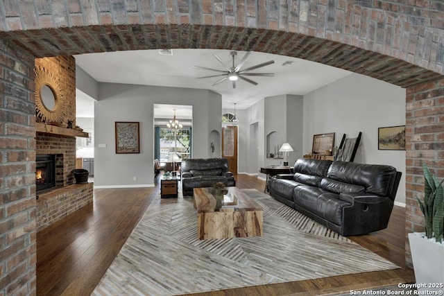 1780 Oak Frst, New Braunfels, TX 78132 - living room featuring visible vents, baseboards, a fireplace, ceiling fan with notable chandelier, and hardwood / wood-style floors