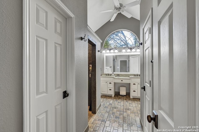 1780 Oak Frst, New Braunfels, TX 78132 - full bathroom featuring lofted ceiling, vanity, a textured wall, ceiling fan, and brick floor