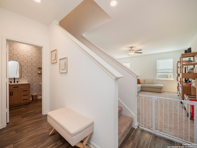 stairway featuring baseboards, a ceiling fan, wood finished floors, and wallpapered walls